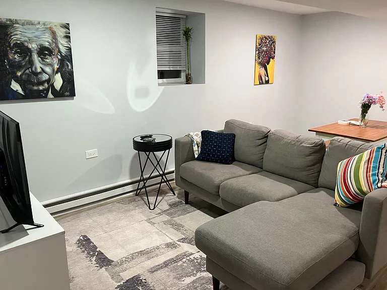 Inviting living area with a sectional sofa, area rug, TV setup, and a pass-through counter ideal for casual dining.