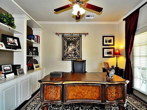 STUDY IS LOCATED TO THE RIGHT OF THE ENTRY WITH CUSTOM BUILD IN CABINETS, CEILING FAN AND WINDOW COVERINGS