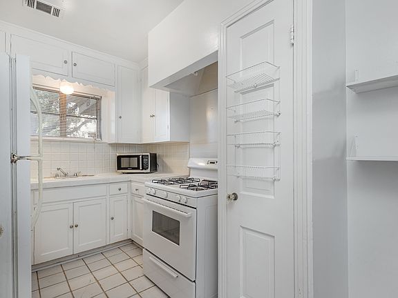 Kitchen with gas stove/oven, refrigerator and microwave.