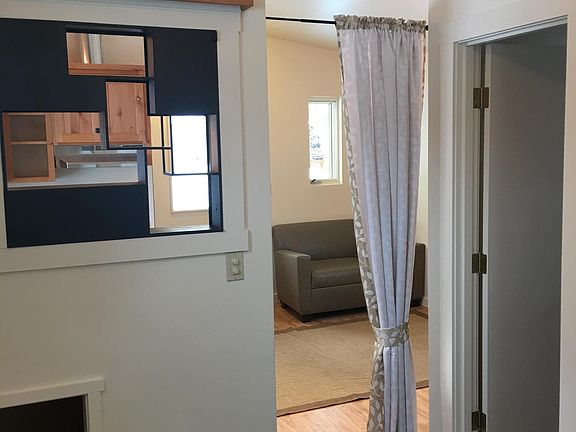 view from bedroom into living area (under wall & upper storage)