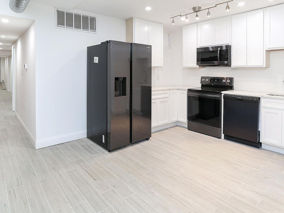 Kitchen with dishwasher, double door refrigerator, microwave, and stove.