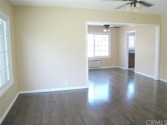 View of the Living Room from the Entry Hall and to the Formal Dining Room Beyond. Refinished Hardwood Floors, Ceiling Fans, New Dual Pane Windows, Freshly Painted