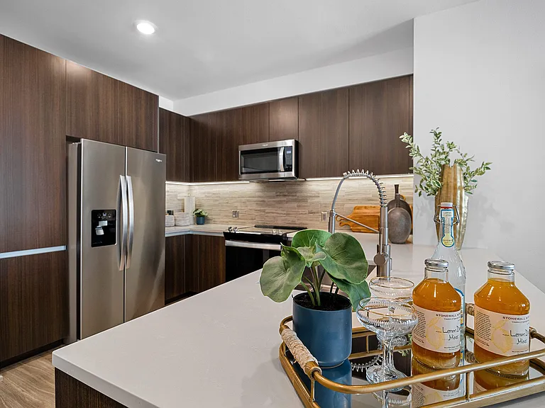 Designer kitchen with stainless appliances and polished island