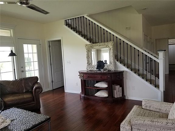 New ceiling fan and new stair railing  grace this comfortable gathering room.