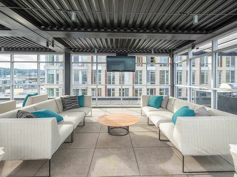 Rooftop deck with outdoor kitchen and lounge seating.