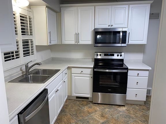 Light bright modern kitchen with all new Whirlpool stainless steel appliances (electric range with ceramic cooktop, built-in microwave, dishwasher, and refrigerator)