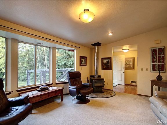 Entry from front deck opens onto wood floor in central location leading to living room, kitchen or family room. Wood burning fireplace heats home great in the winter and large picture windows open up to view.  