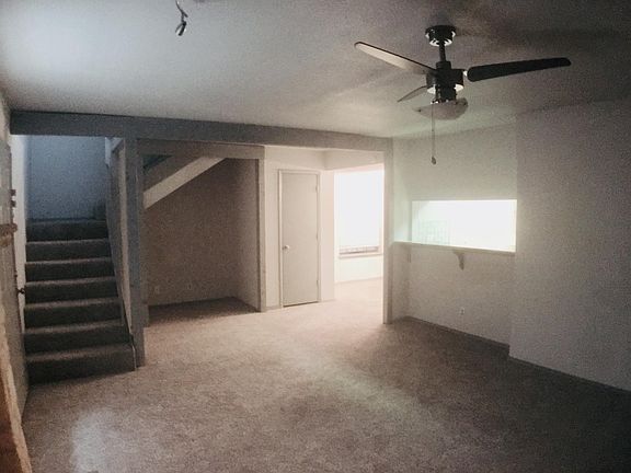 Other side of the living room with a nook under the stairs