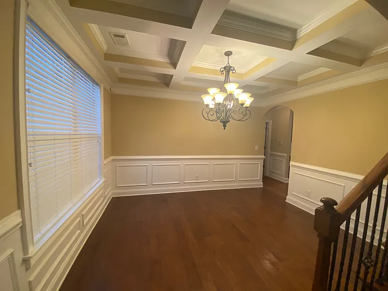 Coffered ceiling with upscale chandelier in formal dining room
