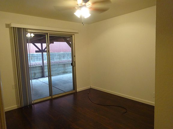 First bedroom with access to back patio and ceiling fan.