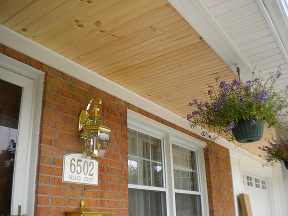 Real-wood overhang at front entry.  Vented soffit and new gutters added