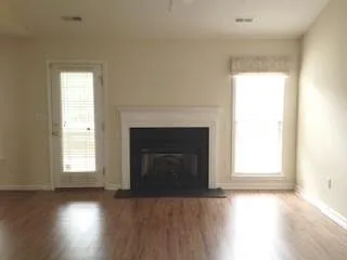 Propane tank gas logs fireplace. Door to porch. Kitchen towards left. Ample room for large screen wall-mount television on wall to left of this view.