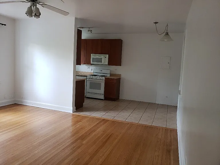 Living room w hardwood floors flows into Eat in Kitchen with tile floors