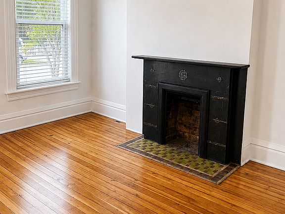 Living room with original decorative fireplace.