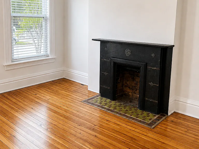 Living room with original decorative fireplace.