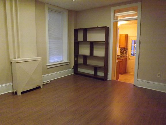 Living Room - 2 large windows let in lots of light. Laminate wood floor. Step down into kitchen and bathroom is off the kitchen to the right. Indoor entrance into this room (behind person taking picture). Bedroom is off this room to the left.