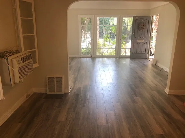 VIEW FROM KITCHEN PASS THROUGH LOOKING OUT INTO DINING AND LIVING ROOM ROOM WITH LARGE FRENCH WINDOWS
