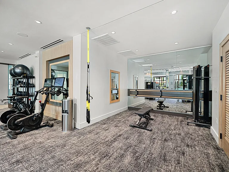 Fitness studio with TRX suspension, spin bikes, and mirrors