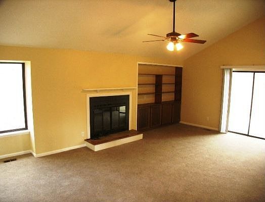 Living Room With Vaulted Ceiling, Fireplace & Built in Bookshelves