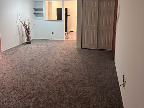 This home features an open-concept living and dining area with a ceiling fan. The spacious, adjacent kitchen is large enough for a table and overlooks the main living space.