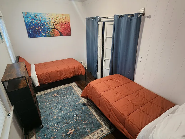 This is the middle bedroom with 2 single beds. Entrance is the french doors in the room with the brown couch.