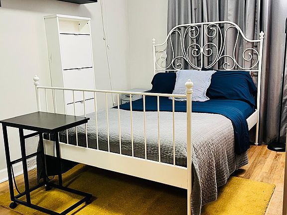 Furnished room full size bed, shoe storage and small rolling table