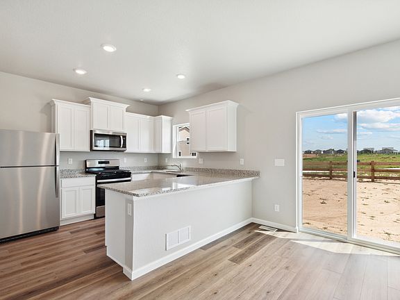 The kitchen of the Laramie has beautiful white wood cabinets.