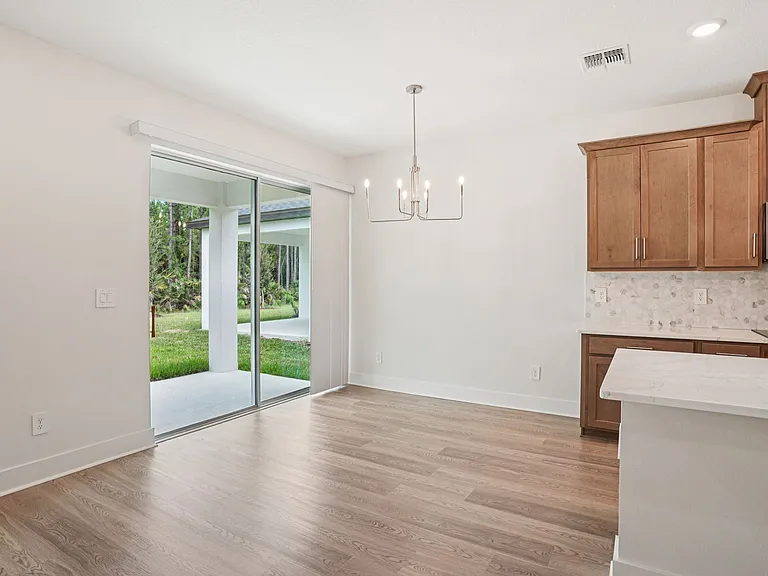 Dining area and kitchen overlooks the backyard and wooded area