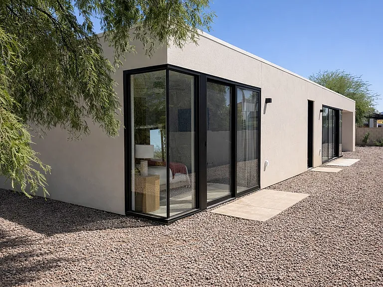 Contemporary casita exterior with clean lines, expansive windows, and a low-maintenance desert yard.