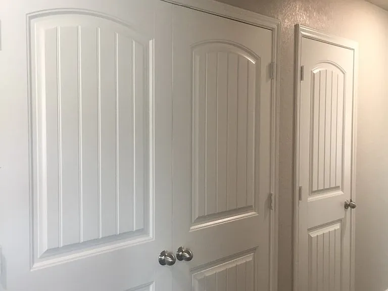 view of washer/dryer room from hallway with doors closed