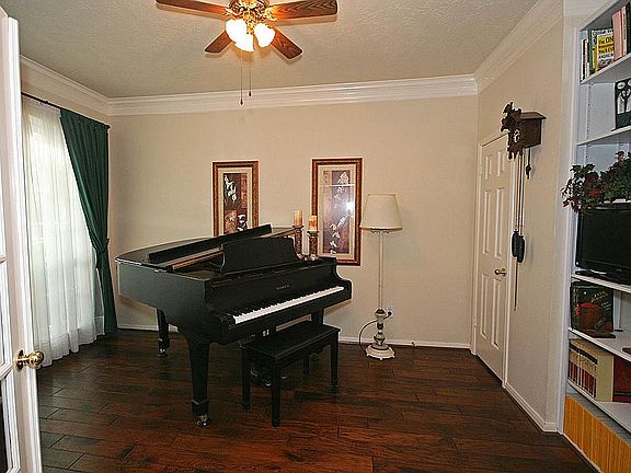 The study has  French doors, crown molding, a closet, and a built in bookshelf.