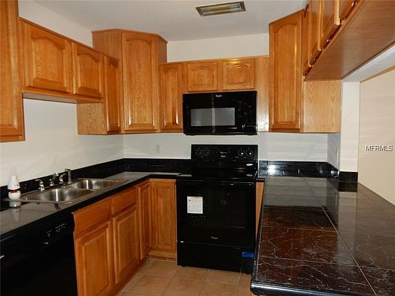 Kitchen with new appliance, wood cabinets and tile counter tops