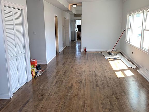 Living room/dining room combo from the front. Stairs to the left, kitchen in the back