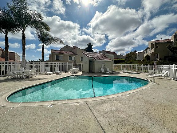 Pool & hot tub area with restrooms, outdoor shower, and plenty of tables and chairs.