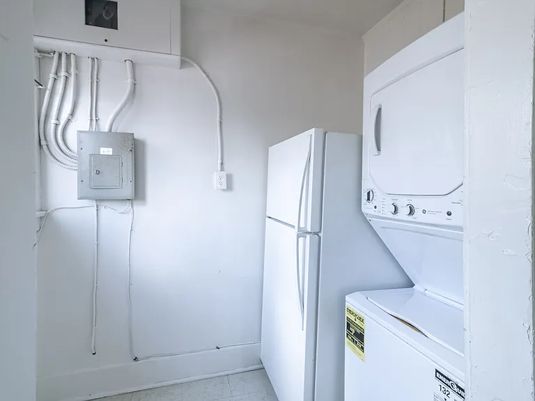 Laundry area and fridge - door to outside pathway with door leading to rear of property/parking