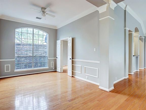 Wide view of expansive dining room. Has stylized features and French doors leading into kitchen.