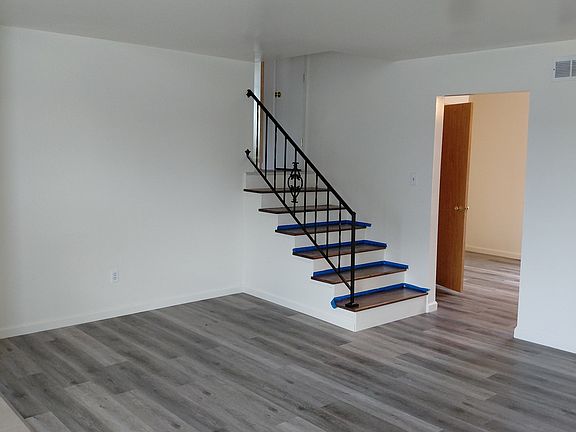 living room with stairs leading to bedrooms and bath