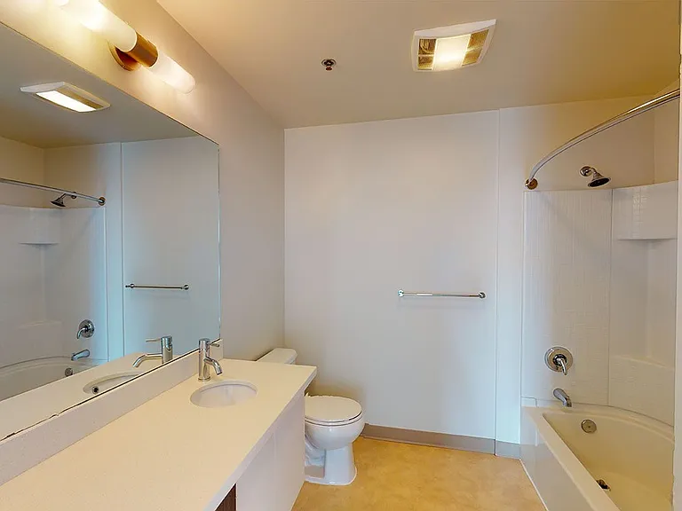 Apartment bathroom with wood-style flooring.