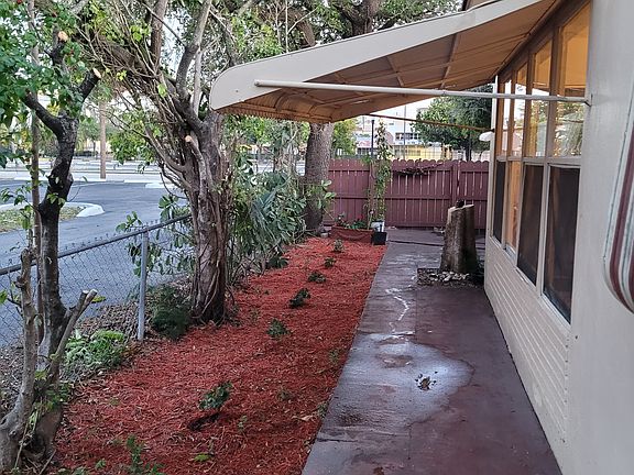 Front yard with the main gate from the large parking lot on the east side of the house. There also is a small back yard with a gate, which provides an easy access from the parking to directly to the kitchen. This helps when caring groceries.