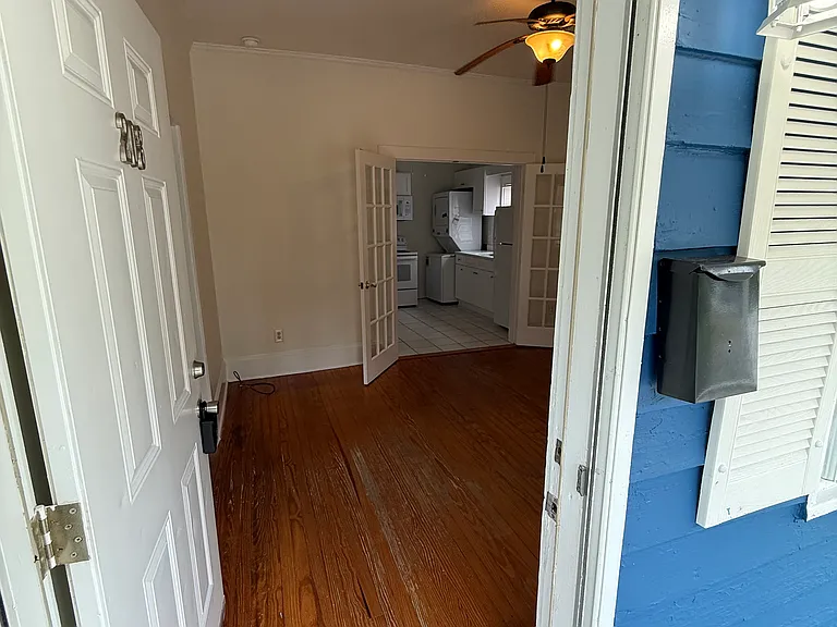 main entrance with view of the living room and kitchen behind French door.