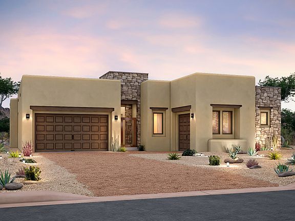 Pueblo style home exterior accented with stone and wood doors on the three-car garage.