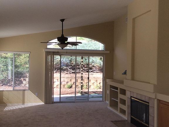 Living Room with Fireplace, Entertainment Center, Ceiling Fan, and Sliding Door to Backyard