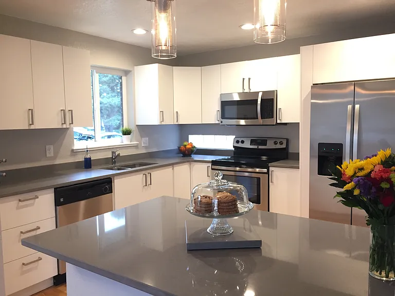 Updated kitchen with plenty of storage, stainless steel appliances, soft close drawers, and natural light.