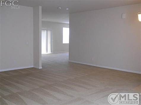 View from the front of the large family room looking into the dining area and sliding doors leading to the lanai