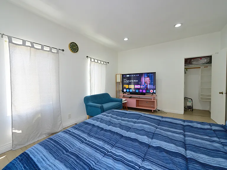 Super spacious bedroom furnished with TV, queen bed and mattress, mini split AC, Loveseat and Coffee table - with views of PCC