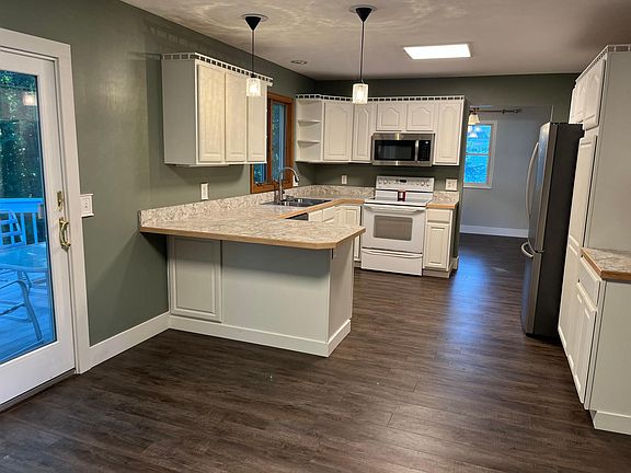 Open, airy kitchen with a ton of natural light. Kitchen/dining overlooks the wooded back yard