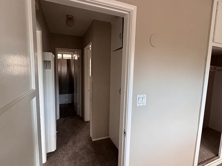 First bedroom with a view of the hallway access to the second bedroom and bathroom