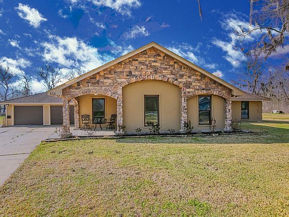 This brick and stone home with a covered front porch offers plenty of parking for all your guests!