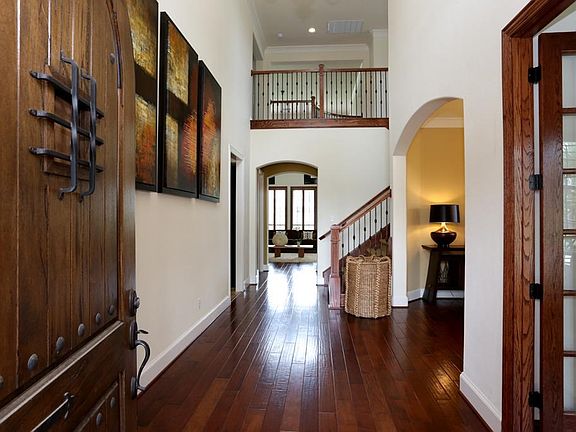 Upon entry, Guests are immediately greeted with loads of architectural interest. High ceilings, arches, loads of heavy crown molding, flowing wood floors & a beautiful wrought iron staircase and landing above unite to please the eye.