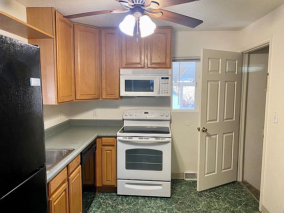 The kitchen has a glass-top stove, dishwasher, microwave,and refrigerator.